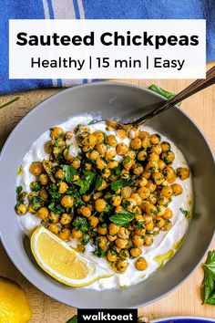 a bowl filled with chickpeas and yogurt next to lemon wedges