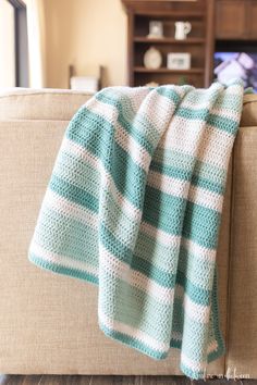 a blue and white blanket sitting on top of a couch