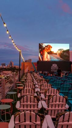 rows of empty chairs in front of an outdoor movie screen