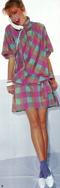 a woman is talking on the phone while wearing a plaid dress