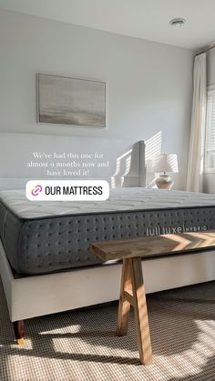 a mattress sitting on top of a bed in a bedroom next to a wooden table