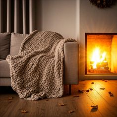 a couch with a blanket on it next to a fire place