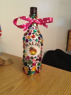 a bottle that has been decorated with many different colors and designs on it, sitting on a table