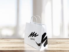 a white shopping bag sitting on top of a wooden table