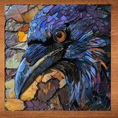 a bird made out of stained glass on a wooden surface with a wood frame around it