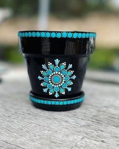 a black and blue flower pot sitting on top of a wooden table