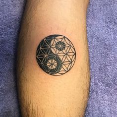 a man's leg with a tattoo on it that has an image of a flower of life in the center