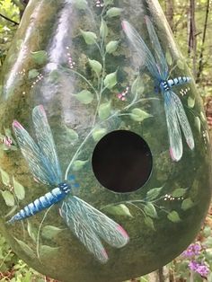 a bird house with dragonflies painted on it