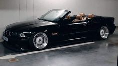 a black convertible car parked in a garage