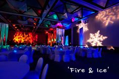 a large room with white tables and chairs covered in blue lights is set up for an event