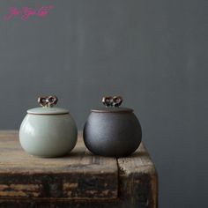 two small pots sitting on top of a wooden table