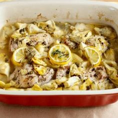 a casserole dish with lemons and meat in it