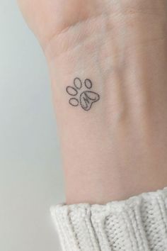 a small paw tattoo on the wrist