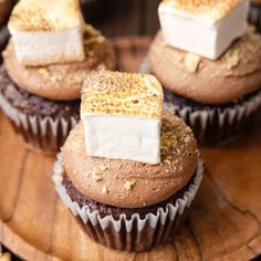 chocolate cupcakes with marshmallow toppings on a wooden plate, ready to be eaten