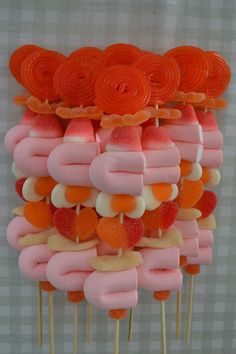 there are many lollipops on the stick with orange and pink toppings