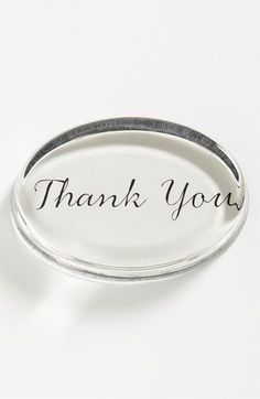 a white plate with the words thank you on it and an oval metal tray underneath