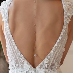 the back of a woman's wedding dress with an elaborate necklace on her neck