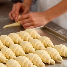 some food is being prepared on a metal counter and ready to be cut into pieces