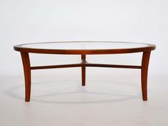 an oval coffee table with glass top and wooden frame, on a plain white background