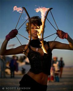 a woman holding two fire sticks in her hands