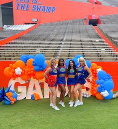 the cheerleaders are posing in front of an orange and blue sign that says, this is the swamp