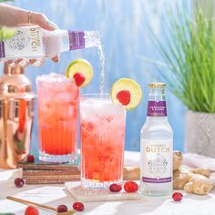 a person pours a drink from a pitcher into two glasses with raspberry lemonade and ginger ale