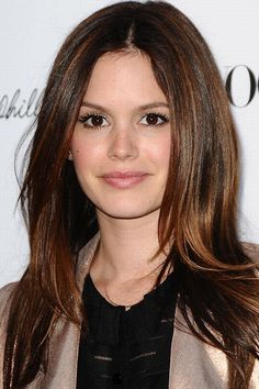 a woman with long brown hair wearing a blazer