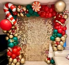 an arch made out of balloons, candy canes and christmas decorations is displayed in front of a couch