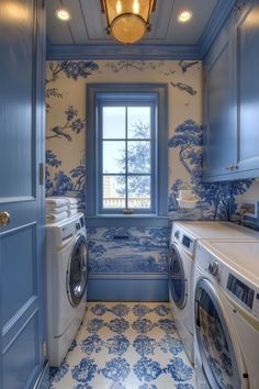 a washer and dryer in a small room with blue wallpaper on the walls