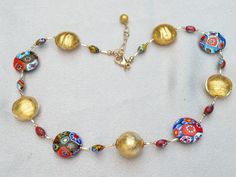 "Millefiori Murano Venetian Glass Bead Necklace; adjustable length, 19 inches to 21 inches with gold filled link chain, and gold filled, large, lobster style spring clasp. I designed this multicolored, mosaic, fine millefiori necklace with 24 karat gold foil beads, to make an outstanding combination. Millefiori translates from Italian to English to mean \"thousand flowers\". Fine Millefiori: Each handmade bead is the finest Millefiori made in Murano. The Murano artisan smooths and polishes each Adjustable Murano Glass Necklace, Adjustable Round Murano Glass Necklace, Adjustable Gold Murano Glass Necklaces, Adjustable Murano Glass Necklace With Round Beads, Adjustable Murano Glass Round Beads Necklace, Adjustable Murano Glass Necklaces With Round Beads, Elegant Multicolor Necklaces With Gold Beads, Czech Glass Jewelry, Murano Glass Necklaces