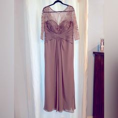 a dress hanging on a hanger in front of a window