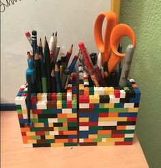 a pencil holder made out of lego blocks with scissors and pens in it on a desk