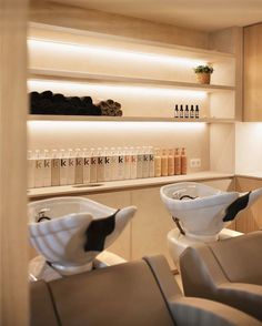 two white bowls sitting on top of each other in front of a shelf filled with bottles