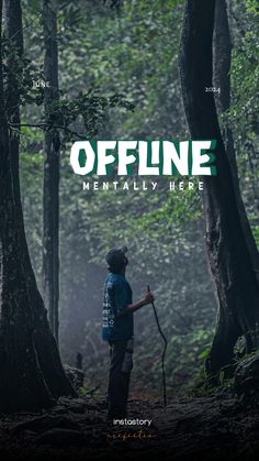 a man standing in the middle of a forest holding a stick and wearing a backpack