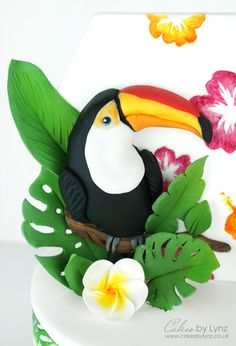 a cake with a toucan and flowers on it