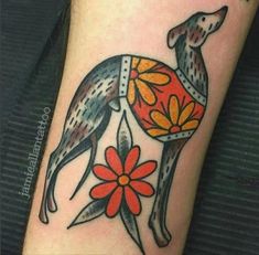 a tattoo with an image of a dog on it's leg and flowers in the background