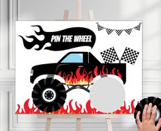 a black monster truck with flames and checkered flags on it's back is shown in front of a white background