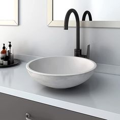 a white bowl sink sitting on top of a counter next to a mirror and soap dispenser