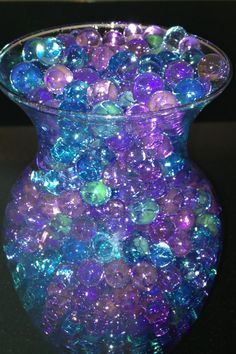 a vase filled with lots of purple and blue beads