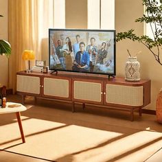 a flat screen tv sitting on top of a wooden entertainment center in a living room