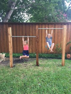 two children are doing pull ups in the yard