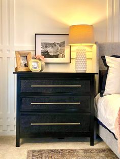 a bedroom with a bed, night stand and pictures on the nightstands in front of it