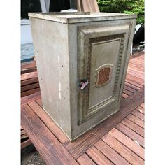 an old metal box sitting on top of a wooden deck