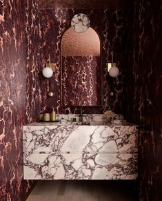 a bathroom with marble counter tops and red walls