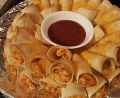 some food is laying out on a table with sauce in a bowl and dipping sauce