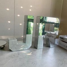 three pieces of glass sitting on top of a table next to boxes and a bowl