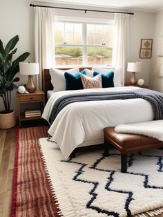 a bedroom with a bed, rugs and two lamps on either side of the window