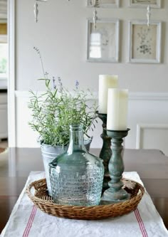 a table topped with two green vases filled with plants