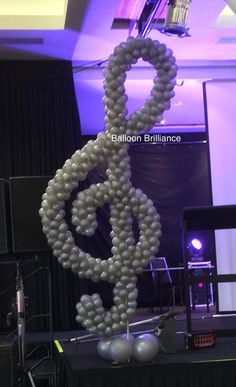 a balloon sculpture made to look like a treble clefs in front of a stage