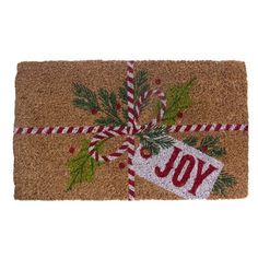 a christmas door mat with the word joy on it and a candy cane wrapped in ribbon